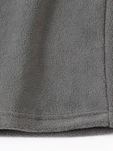 Primer plano de la textura de tela polar gris con detalle de costura en el dobladillo