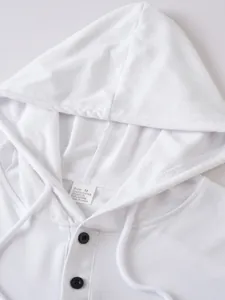 Close-up detail of white buttoned hooded sweatshirt with material composition tag
