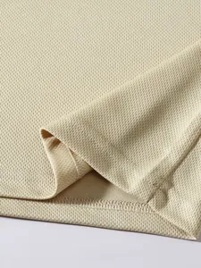 Close-up of breathable mesh fabric and double-stitched hem on beige sports tank top