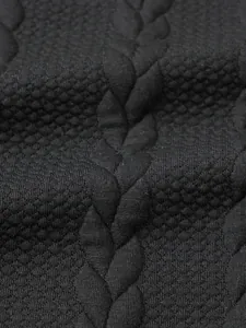Primo piano dettagliato della maglia a trecce nera e della pregiata trama a nido d'ape