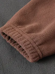 Primer plano detallado del puño elástico de una sudadera de forro polar marrón cálida