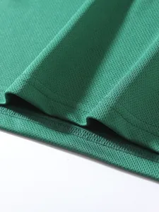 Macro detail showing breathable mesh fabric and high-quality stitching on green sportswear.