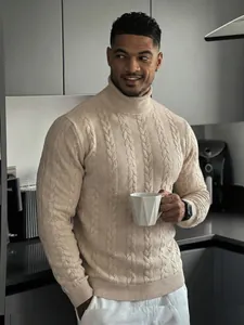 Dettaglio del maglione beige a collo alto in maglia a trecce con trama fitta