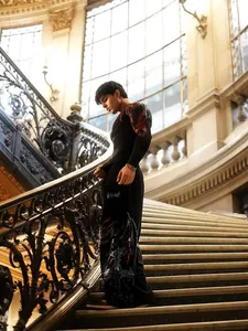 Men's black compression shirt with red graphic print shown in a grand interior setting