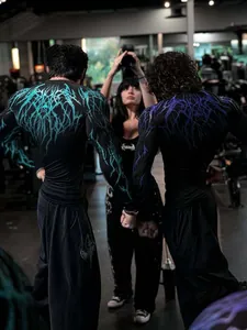 Detailed view of men's gym compression shirts with teal and purple gothic patterns