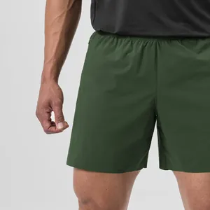 Detail shot of men's dark green woven quick-dry running shorts worn by athlete