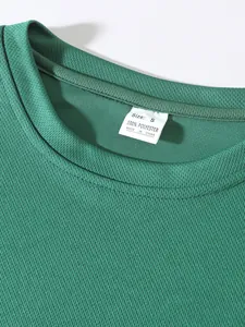 Detailed macro view of green mesh athletic top showing 100% polyester care label.