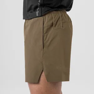 Close-up of brown quick-dry woven sports shorts showing side pocket and split hem detail