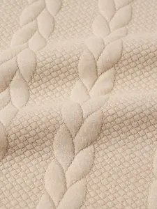 Macro dettaglio della maglia a trecce beige e della trama jacquard per maglione invernale