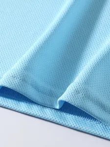 Close-up of breathable light blue mesh fabric and hem of men's sports tank top.