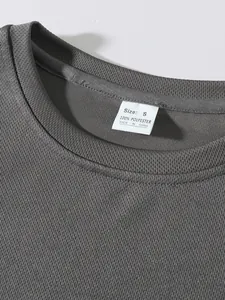 Detail view of men's dark grey mesh gym vest showing breathable texture and size label