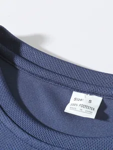 Close-up of the breathable mesh fabric and size label on a blue sports T-shirt