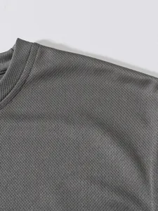 Close-up detail of grey breathable mesh fabric texture on a men's sport tank top.