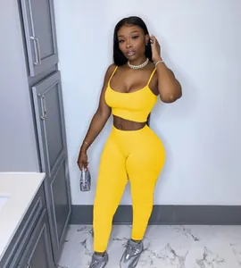 Detail of yellow two-piece set featuring spaghetti strap crop top and high-waisted leggings.