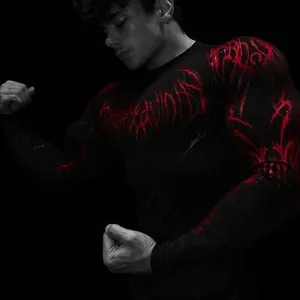 Detail view of men's athletic compression shirt featuring bold red gothic graphics