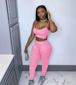 Women's bright pink two-piece athletic set with cropped camisole and slim-fit yoga leggings.