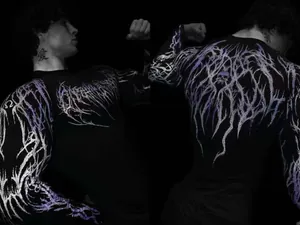 Close-up of men's compression gym shirt with purple lightning graphics and skull motif on back