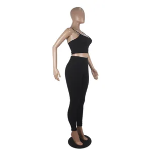Women's black two-piece set featuring spaghetti strap crop top and leggings