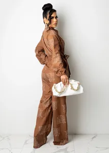 Detailed view of women's brown shirt long sleeve jumpsuit with script print and belt