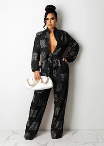 Elegant black long sleeve jumpsuit with white script print and matching belt detail