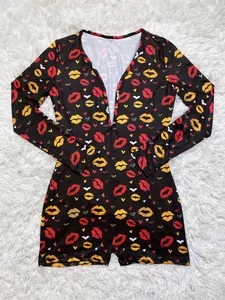 Close-up of the vibrant heart and lip pattern on a black long sleeve pajama romper