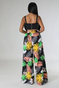 Rückansicht von weit geschnittenen Hosen mit tropischem Blumenmuster und schwarzem Crop-Top.