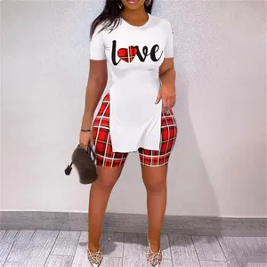 Ensemble deux pièces avec tee-shirt blanc Love à fente latérale et short à carreaux.