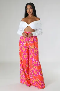 Ganzkörperansicht der lebhaften orange-pinkfarbenen Weithose mit Blumenmuster und Taschen