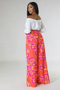 Modische weite Hose mit orangefarbenem Blumendruck und elegantem weißem schulterfreiem Top