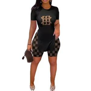 Ensemble deux pièces noir pour femme avec imprimé monogramme doré et haut fendu élégant