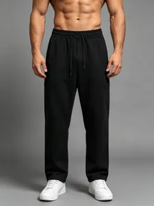 Detail view of men's loose black quick-dry sports pants with straight-leg cut on model