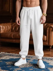 Detail view of men's white breathable casual jogger pants worn by a model in a luxury room