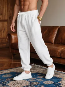 Man wearing white breathable linen jogger pants in a stylish living room setting