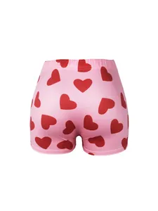 Vue détaillée d'un short de yoga rose avec un motif imprimé de cœurs rouges éclatants