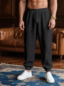 Detailed view of breathable black joggers with drawstring waist and cuffed hem in studio
