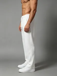 Detail view showing the side fit of men's loose white quick-dry cotton fitness sweatpants