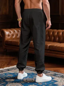 Back view of men's black lightweight breathable jogger pants in a luxury interior setting