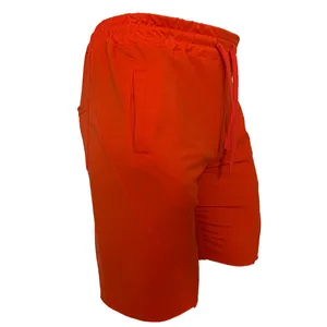 Seitenansicht-Detail der leuchtend orangefarbenen Sporthose mit Tasche und Kordelzug