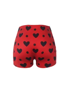 Vue détaillée du short moulant rouge avec motifs de cœurs et pois noirs.