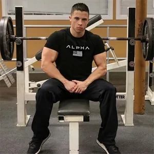 Men's black performance athletic fitness t-shirt with Alpha print in gym setting