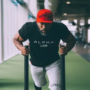 Close-up of a muscular man in a black Alpha gym t-shirt during a fitness workout