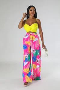 Modisches zweiteiliges Outfit mit gelbem Crop-Top und pinker Weitbeinhose mit Blumendruck