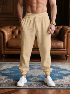 Men's breathable beige linen joggers shown in a high-end casual living room setting