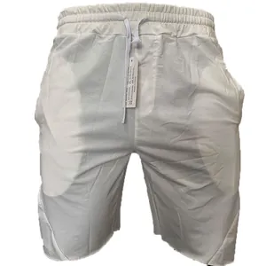 Detaillierte Makroansicht der weißen Sport-Shorts mit Kordelzug und offener Saumkante