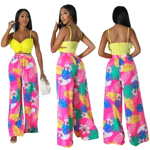 Modisches zweiteiliges Set mit gelbem Crop-Top und pinker Hose mit tropischem Blumenmuster.