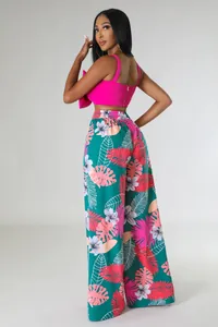 Detailansicht der weiten Hose mit Tropenmuster und pinkem Crop-Top für Damenmode.