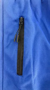 Detailaufnahme der blauen atmungsaktiven Mesh-Sporthose mit schwarzer Reißverschlusstasche