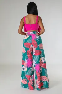 Rückansicht einer Frau in einem rosa Crop-Top und weit geschnittener Blumenhose