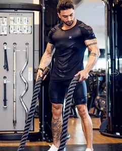 Action shot of men's black quick-dry compression gym wear during battle rope training session