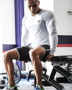 Dettaglio della maglia a compressione a maniche lunghe da uomo con logo atletico.